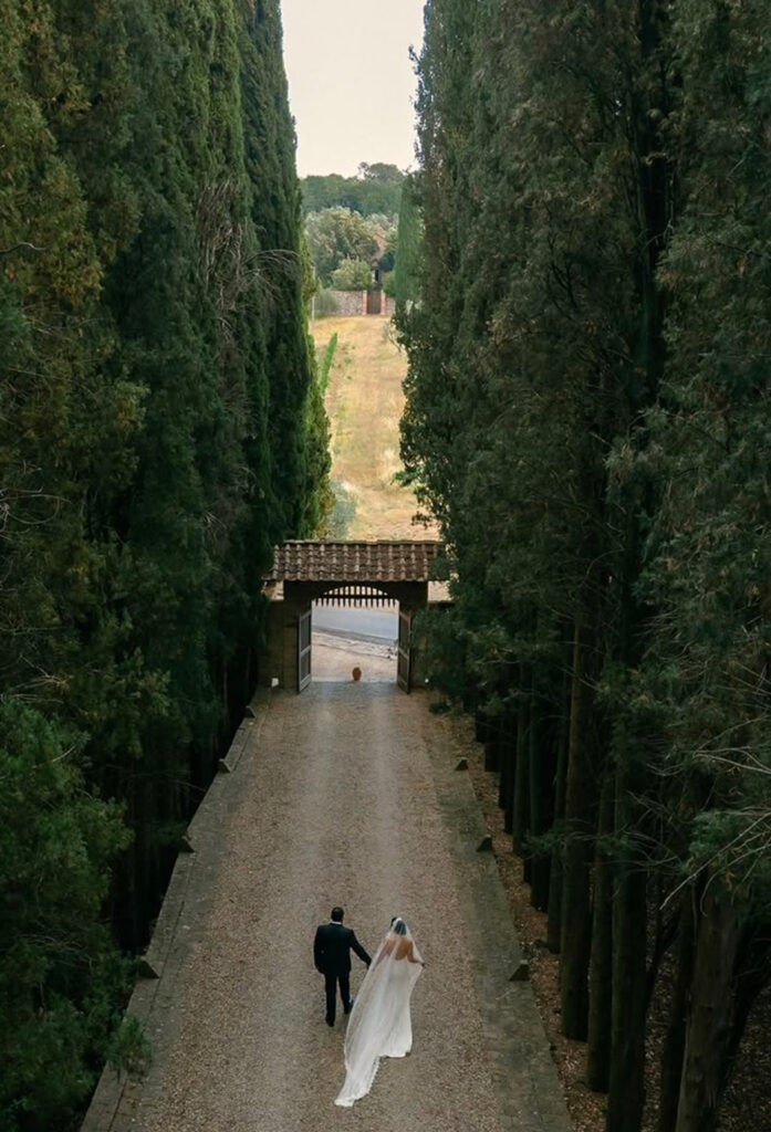 Historic Tuscan building framed by tall cypress trees