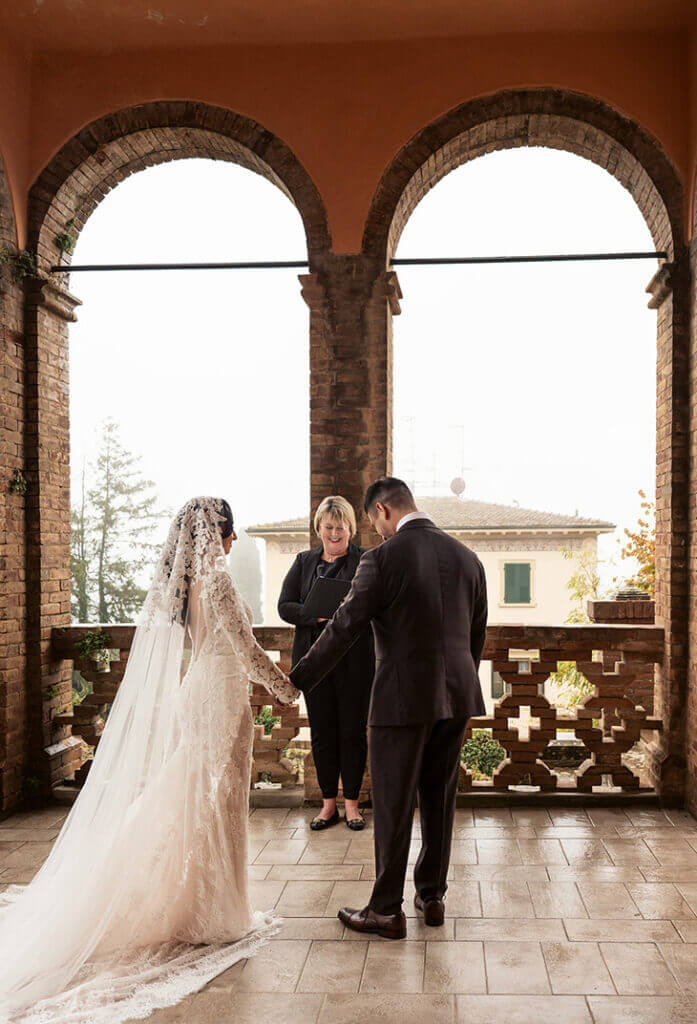 Couple exchanging vows beneath the arches of a Tuscan villa