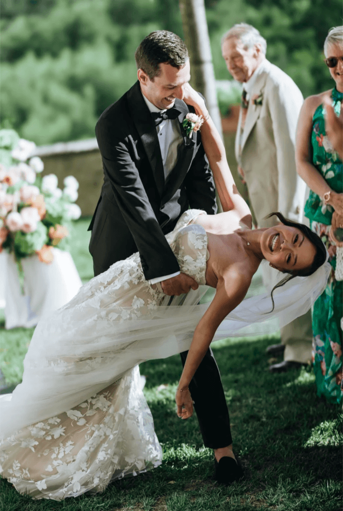 Smiling newlyweds celebrating together after their outdoor wedding ceremony